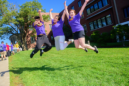 students in purple shirts jumping