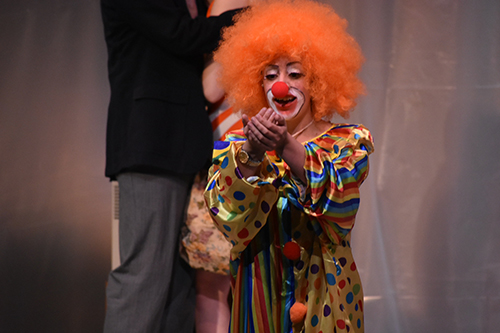 student on stage in clown costume